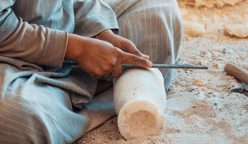 A man carving stone into a vase